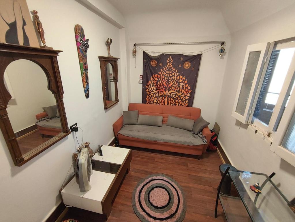un salon avec un canapé et un miroir dans l'établissement Artistic Flat by Luxor Temple & Ancient Souq, à Louxor