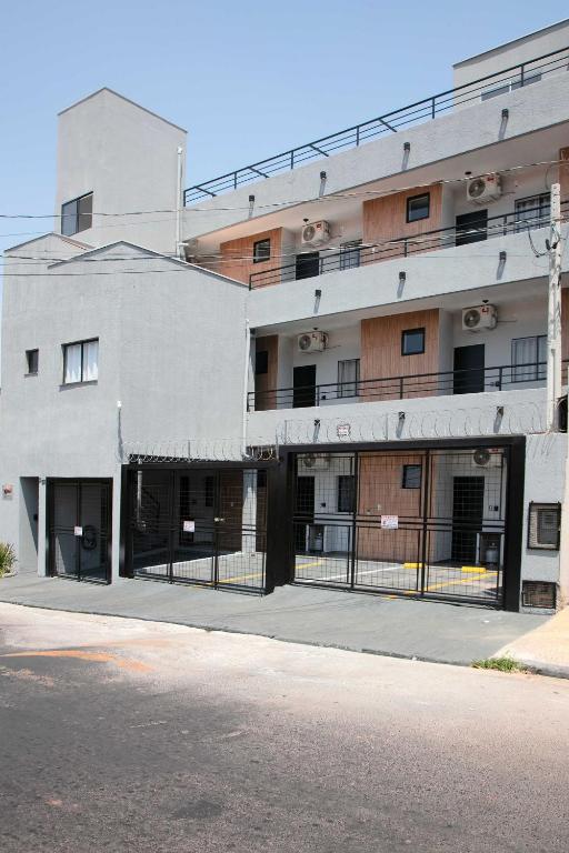 a white building with a fence in front of it at Xavi Studio - Sem Vaga de Garagem in Bauru