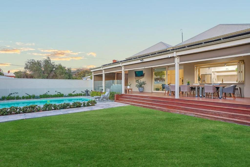 a house with a patio and a yard with a lawn at Retreat on Chaffey in Mildura