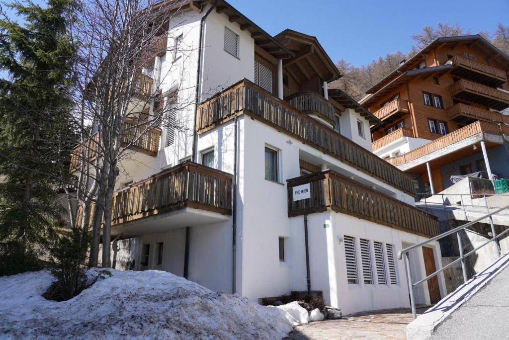 a white building with a balcony on top of it at Fee-Rien in Saas-Fee