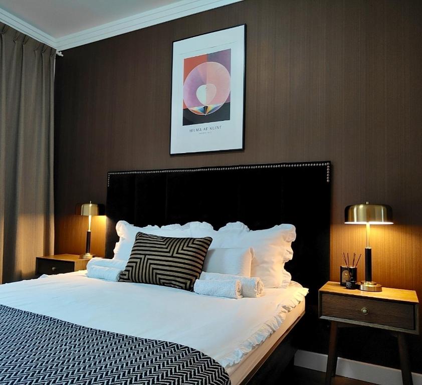 een slaapkamer met een groot wit bed met twee lampen bij Apartament N7 Centrum in Gorzów Wielkopolski