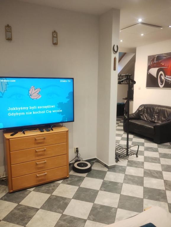 Una sala de estar con un televisor de pantalla plana sobre una cómoda. en Apartament Pod Bukami, en Łaziska Górne