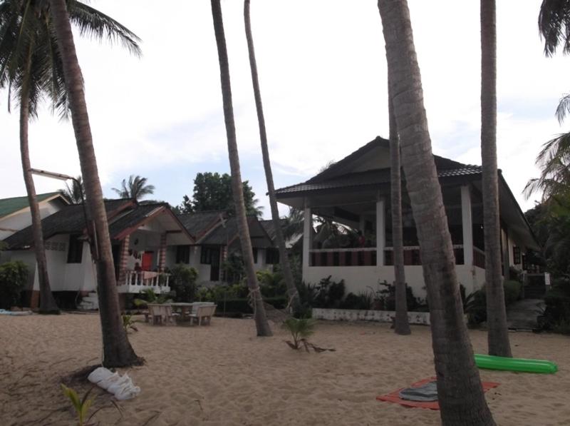 a house on the beach with palm trees at Palm Point Village in Mae Nam