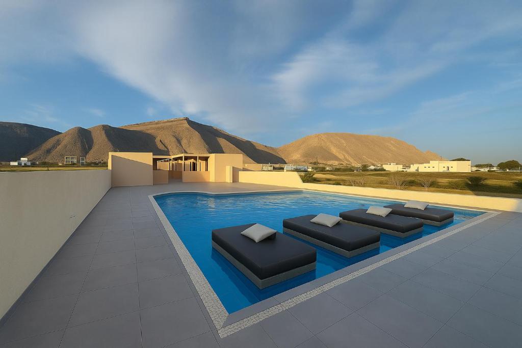 représentation d'une piscine avec quatre chaises longues dans l'établissement Tinamar Selections, à Perivolos