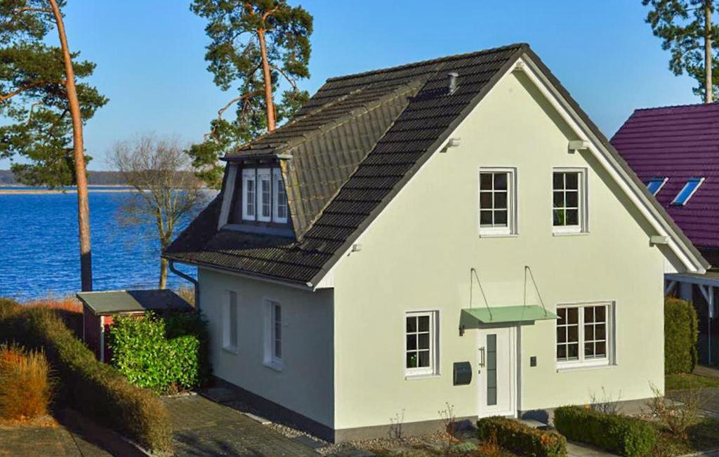 una casa bianca con il tetto nero vicino all'acqua di H7 Og a Marienfelde