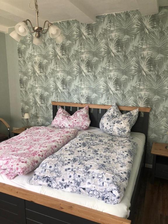 a bedroom with a bed with floral sheets and pillows at FeWo M Becker 