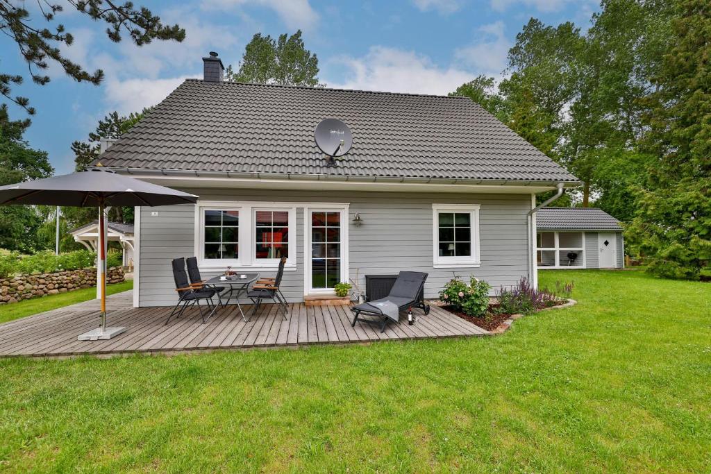 a house with a deck with a table and chairs at Ferienhaus Hygge - nordisches Flair in Toplage in Wiek auf Rügen