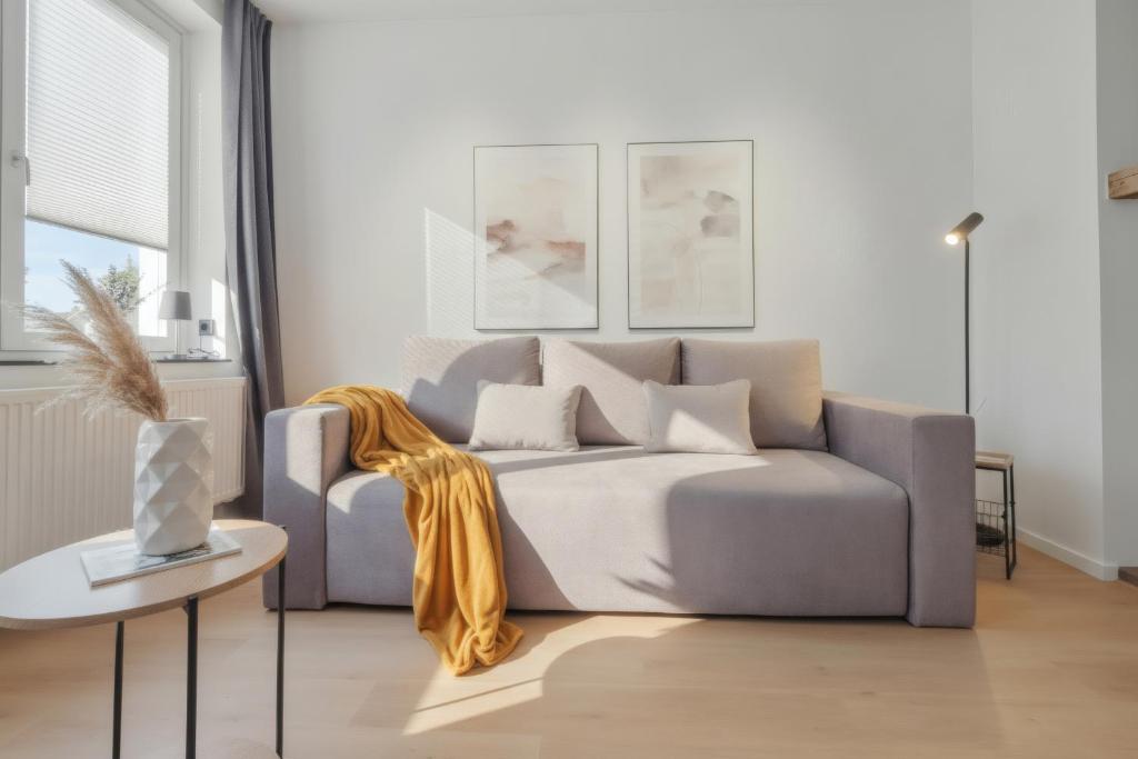 a living room with a couch and a table at MILPAU Herne1 - Zentrales, modernes Design-Apartment - Smart TV, Nespresso für 4 Personen in Herne