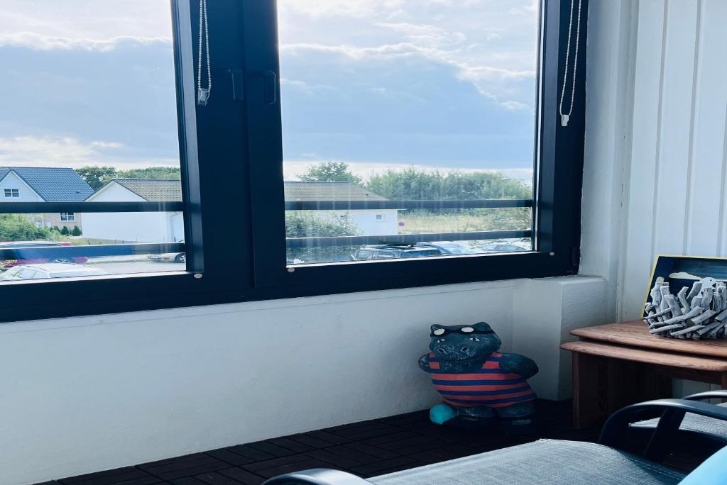 una stanza con una finestra e un animale di peluche accanto a un tavolo di Ferienwohnung Kajüte 7211 Marina Wendtorf a Wendtorf