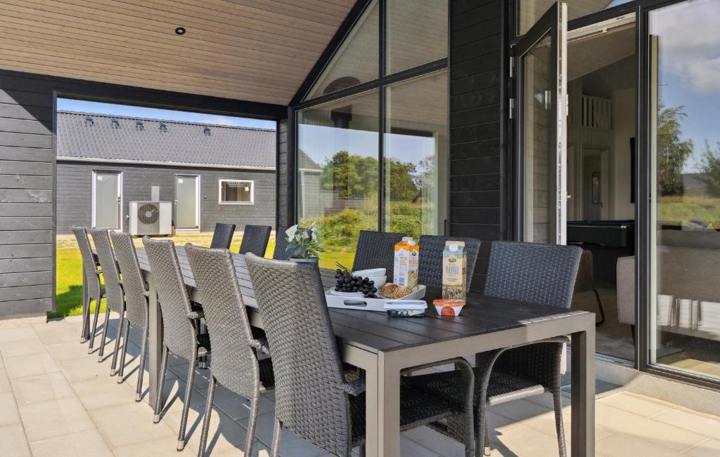 a dining table and chairs on a patio at Amazing Home In Glesborg With Sauna in Fjellerup