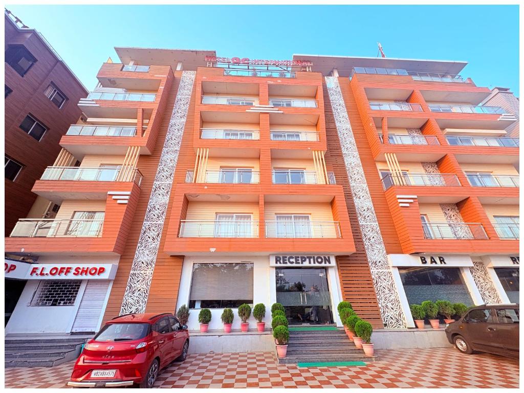 an orange apartment building with a red car parked in front at GC INTERNATIONAL - New Digha Sea Beach Hotel with SWIMMING POOL, PARKING, PRIVATE GYM, RESTAURANT in Digha