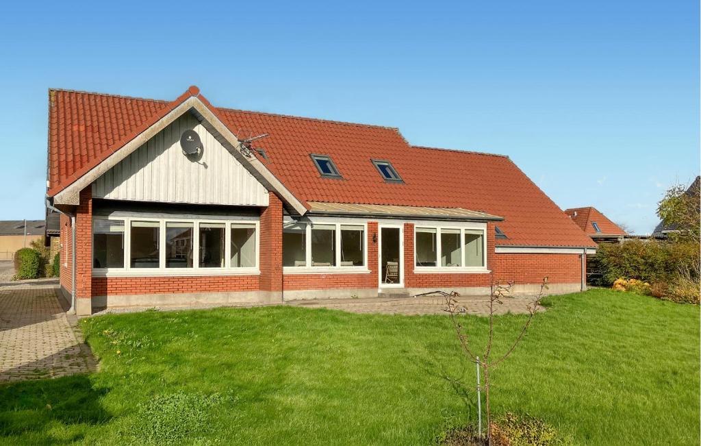 a red brick house with a green yard at 5 Bedroom Awesome Home In Lemvig in Nørby