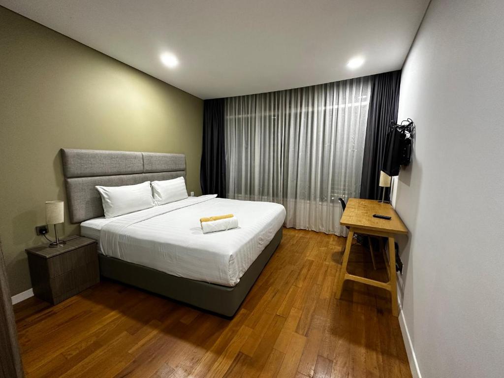a bedroom with a bed and a table and a television at Soho suites klcc by Kualalampur twin tower vibes in Kuala Lumpur