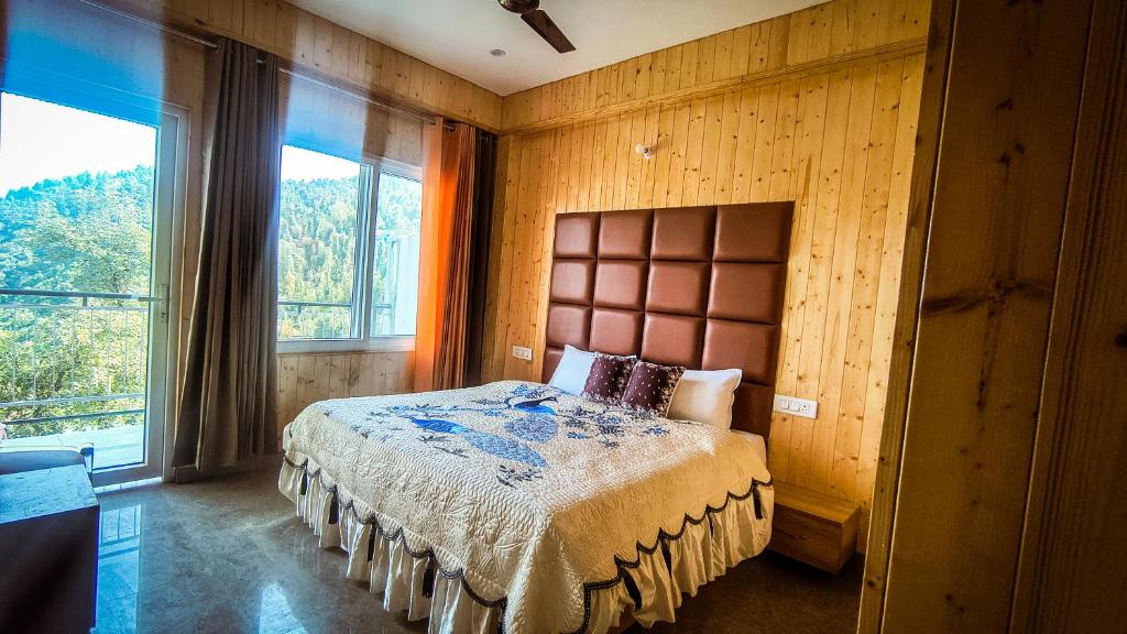een slaapkamer met een bed en een groot raam bij Oak sunlight Restaurant & Provides Famous Gadwali food in Mussoorie