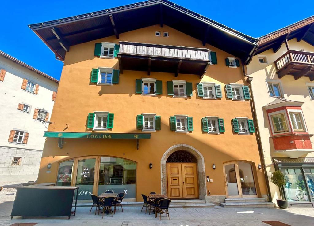 a building with tables and chairs in front of it at Löw Chalet Suite 3 in the heart of Kitzbühel by 360 Estates in Kitzbühel