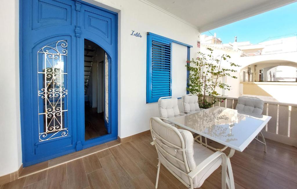 a dining room with blue doors and a table and chairs at Stunning Home In Piles With Wifi in La Playa de la Torre de Piles