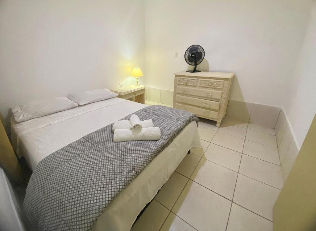 a bedroom with a bed with a towel on it at Casa no centro histórico de São João del- Rei in São João del Rei