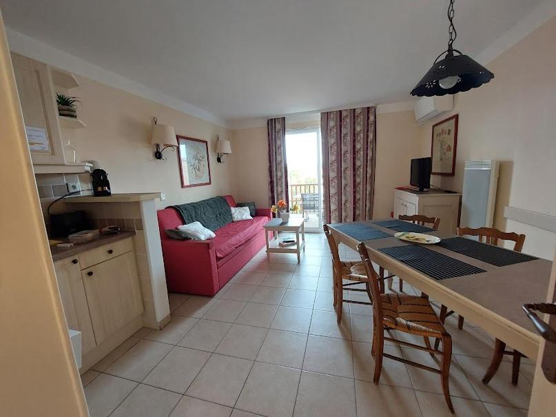 eine Küche und ein Wohnzimmer mit einem rosa Sofa in der Unterkunft Maison 3 pièces domaine golf Pont Royal in Mallemort