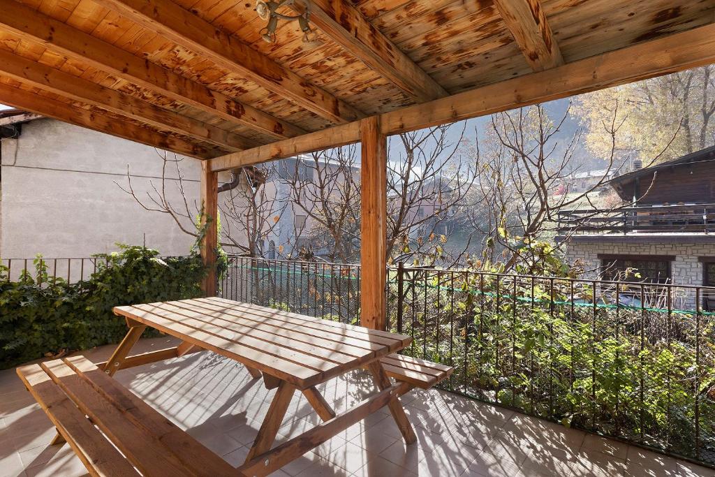 a wooden bench sitting under a wooden pergola at Da Roby - Villa Carolina in Fenis