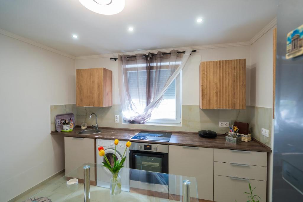 a small kitchen with a stove and a window at Non stop apartman 1 in Kaposvár
