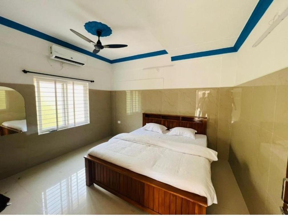 a bedroom with a bed and a ceiling with blue paint at vks holiday homes in Malpe