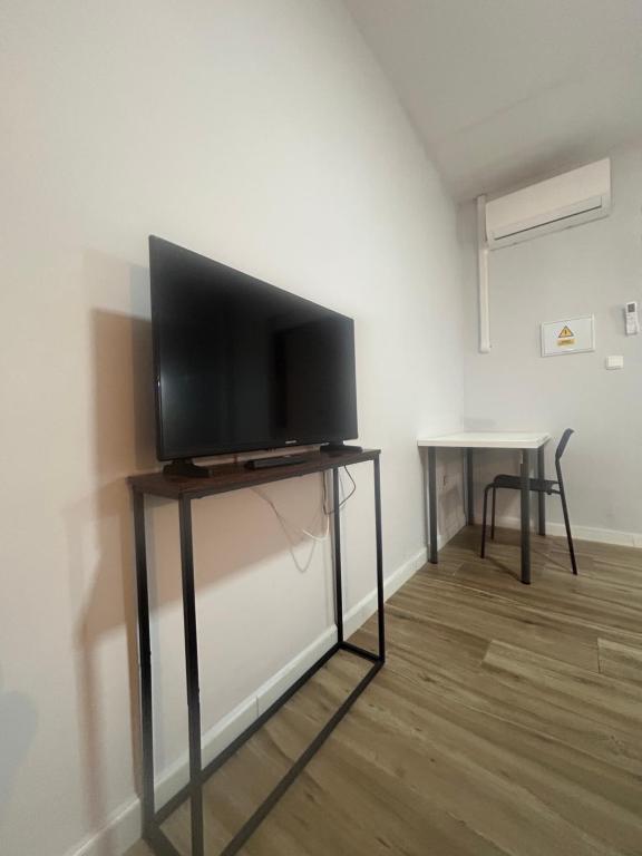 a flat screen tv sitting on a stand in a room at Apartamento Alfacar in Alfacar