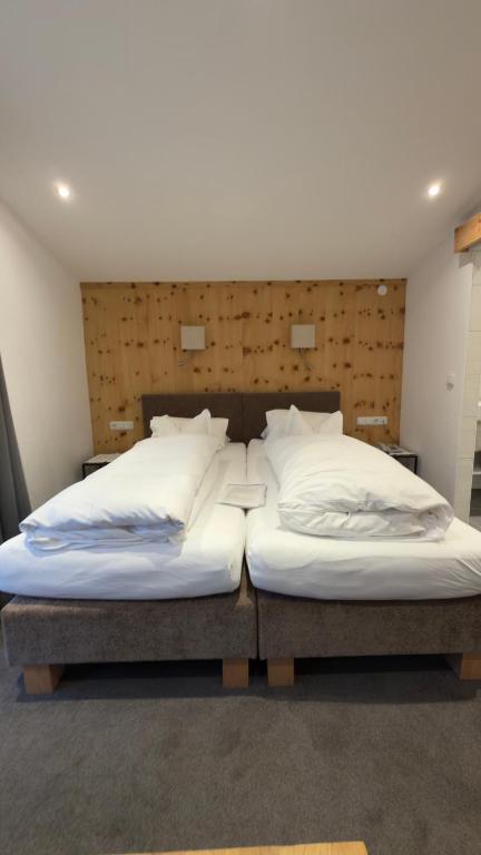 two beds sitting next to each other in a room at Hotel Sailer in Sankt Anton am Arlberg