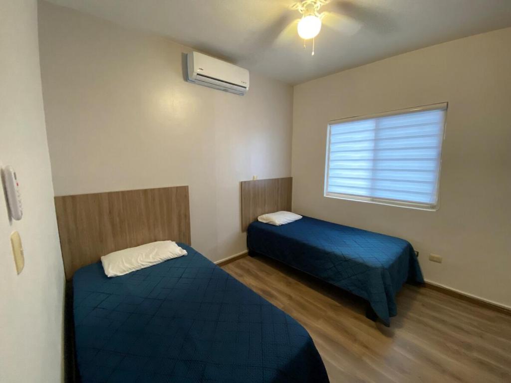 ein kleines Zimmer mit zwei Betten und einem Fenster in der Unterkunft Casa al Norte, cerca Zona Industrial, Bien ubicado in Ramos Arizpe