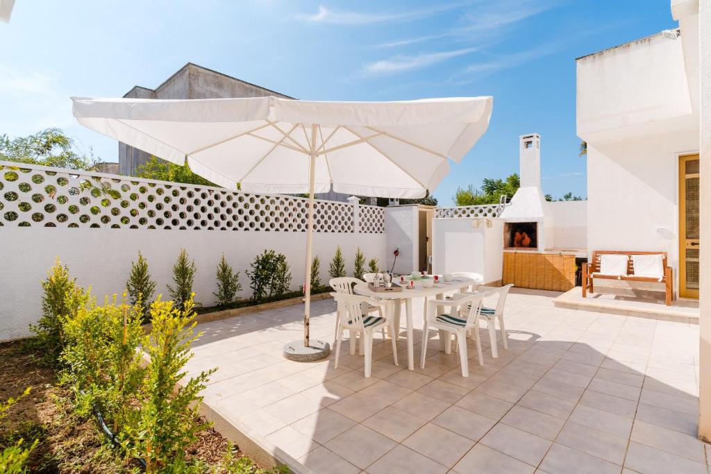 un patio avec un parasol, une table et des chaises dans l'établissement Villa Greta, à Isola della Malva