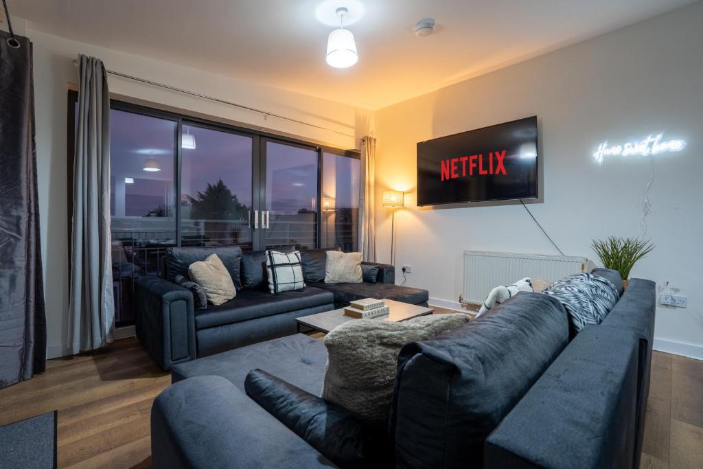 ein Wohnzimmer mit einer Couch und einem Fernseher an der Wand in der Unterkunft Penthouse in Central Nottingham with Hot tub and Games in Nottingham