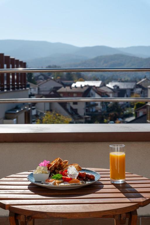 a plate of food on a table with a glass of orange juice at DolceVita Lux & SPA in Vrnjačka Banja