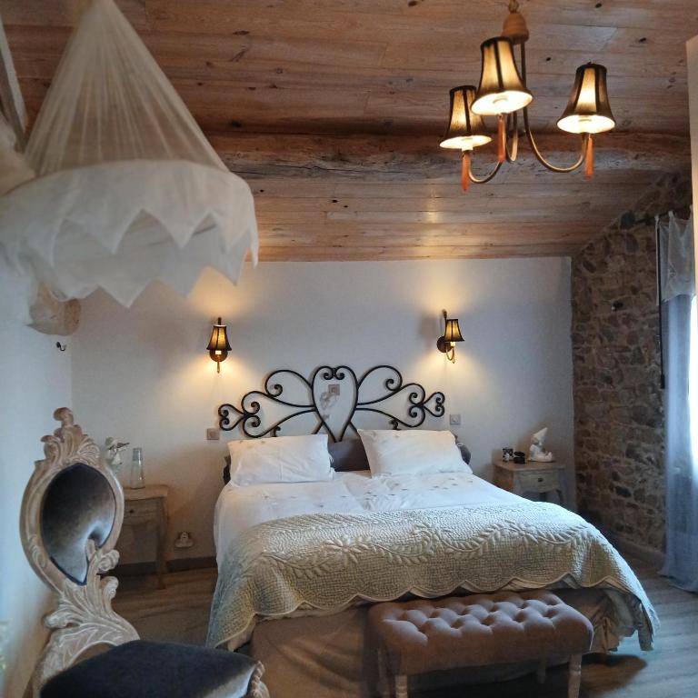 a bedroom with a bed and a chandelier at Le Clos du Merle in Savigny