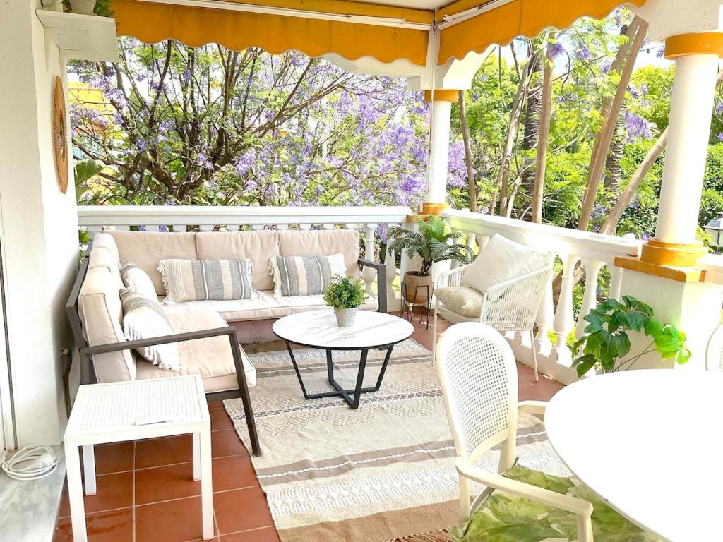 a porch with a couch and a table and chairs at Marbella - Puerto Banus in Marbella