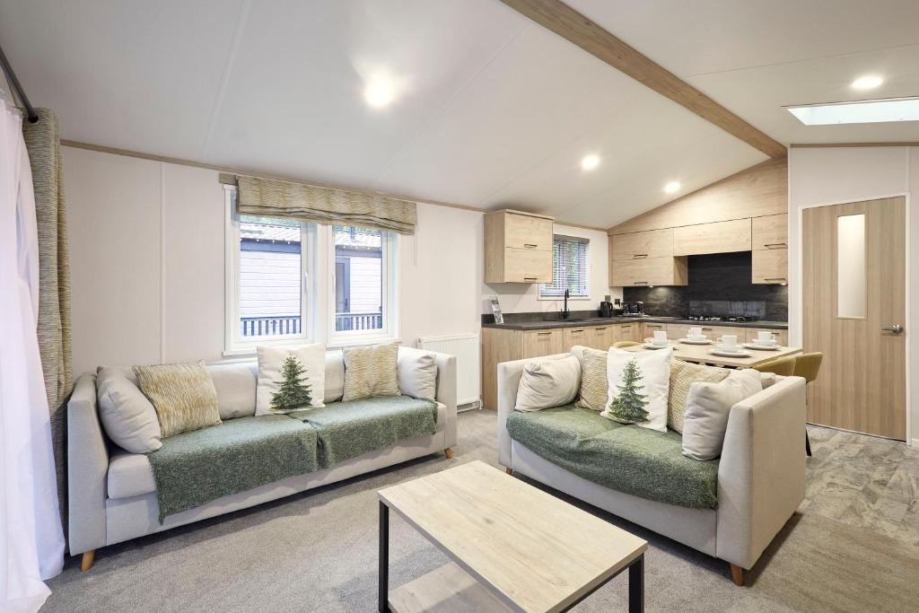 ヨークにあるFir Tree Lodge with Hot Tubのリビングルーム(ソファ2台付)、キッチンが備わります。
