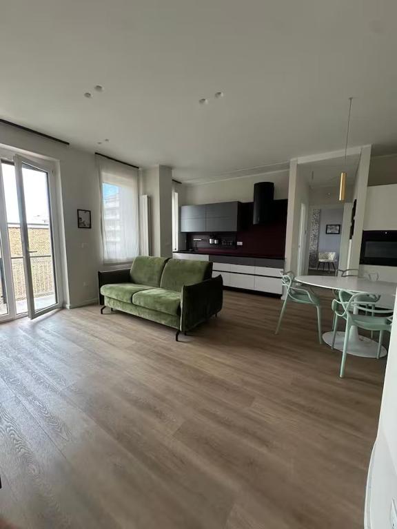 ein Wohnzimmer mit einer grünen Couch und einem Tisch in der Unterkunft Suite Design in Pescara