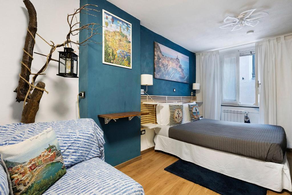 a bedroom with two beds and a blue wall at Ca Du Grifun - Vernazza in Vernazza