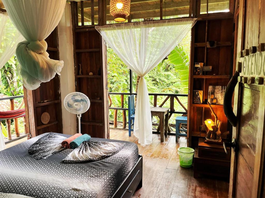 Un dormitorio con una cama en una habitación con ventana. en Utria hostel, en El Valle