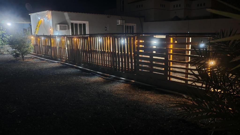 a fence in front of a house at night at Atiaf Jabal Shams house in Misfāh