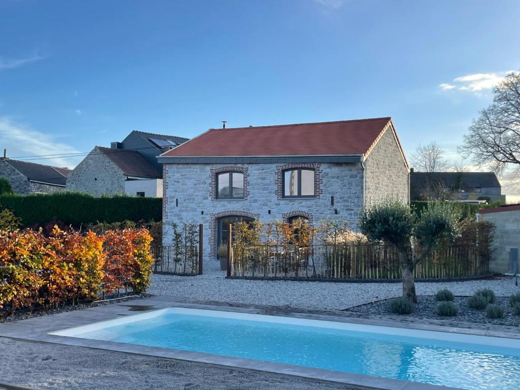 een huis met een zwembad ervoor bij Le Gîte du Pèlerin avec piscine in Florennes