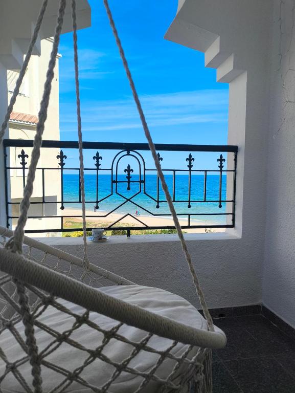 a hammock in a room with a view of the ocean at Vitamin Sea Apartment in Akouda