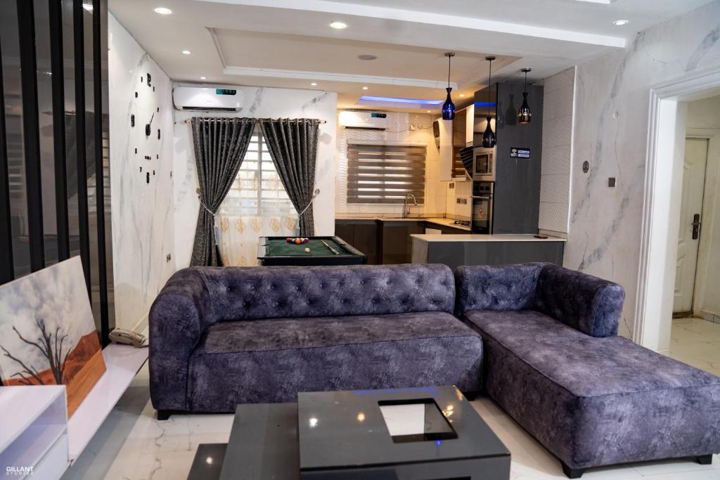 a living room with a couch and a pool table at Gillant Luxury Homes in Benin City