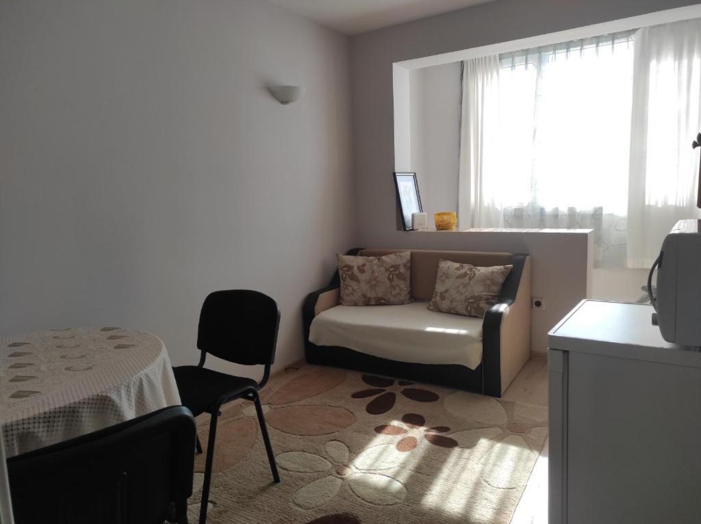 a living room with a couch and a chair at 2 rooms apartment in the center in Nesebar