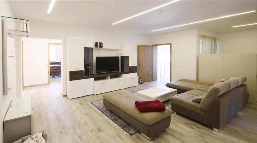 a living room with a couch and a flat screen tv at Haus am Fischteich in Feistritz ob Bleiburg