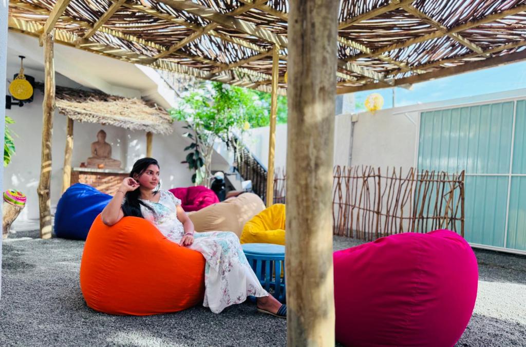 Eine Frau sitzt auf einem Sitzsack und telefoniert. in der Unterkunft The Lotus House - Ahangama in Ahangama