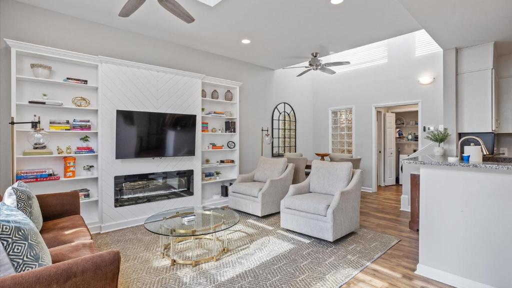 a living room with a couch and chairs and a tv at Downtown Condo - 2BR 2BA Walk to Everything in Raleigh