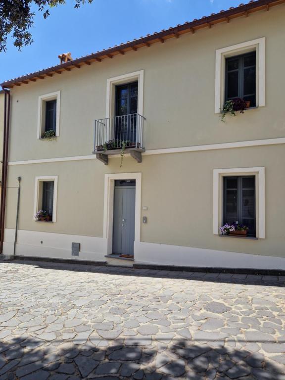 a white house with two windows and a door at Casa S'Urtzula in Sini