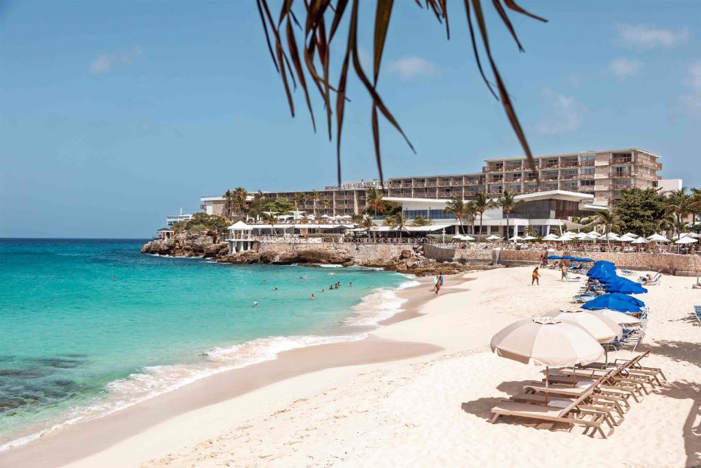 a beach with chairs and umbrellas and the ocean at Royal Islander Club Resort La Terrasse in Lowlands