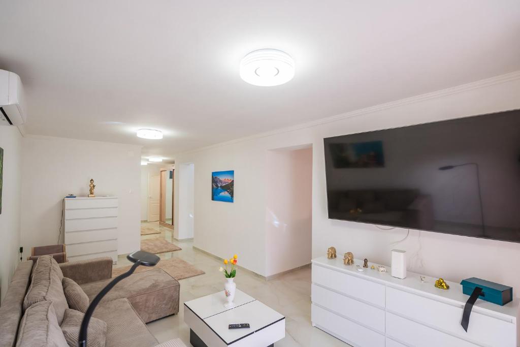 un salon avec un canapé et une grande télévision à écran plat dans l'établissement Non stop apartman 1, à Kaposvár