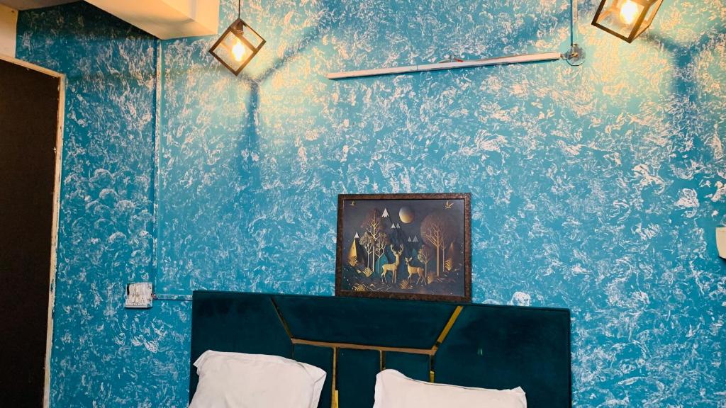 a room with a blue wall with a picture on it at Glory hotel in Noida