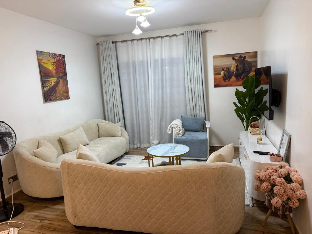 a living room with a couch and a table at Cozy 2 BR Tatu City - Unity Homes in Oloyaingalani